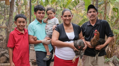A family holding chickens   