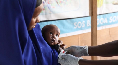 A woman holds her baby during a health check-up