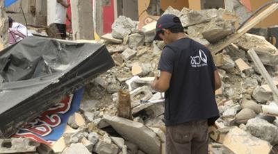 workers survey quake damage in Ecuador