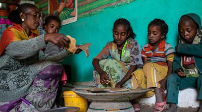 Woman and children from Ethiopia share dinner