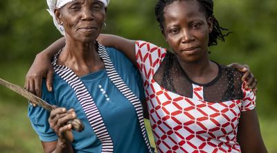 Nora Tolee and Martha Yelekor farm cassava with their neighbors in Nimba County, Liberia. 