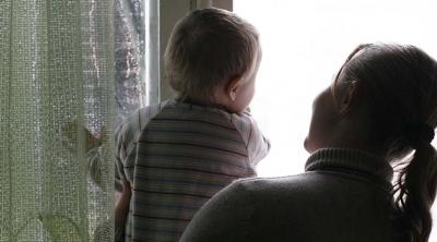 A woman and child look out a window in Ukraine