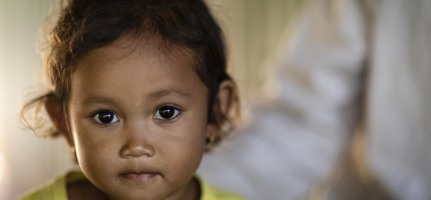 Una niña pequeña sonriendo a la cámara