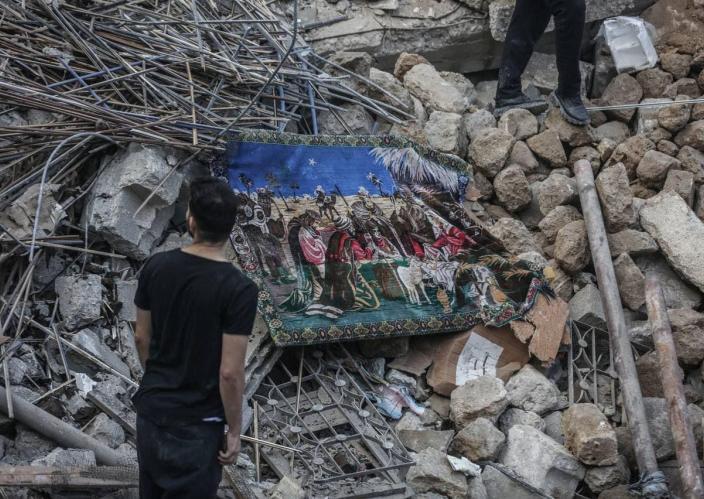 A man standing in front of rubble.