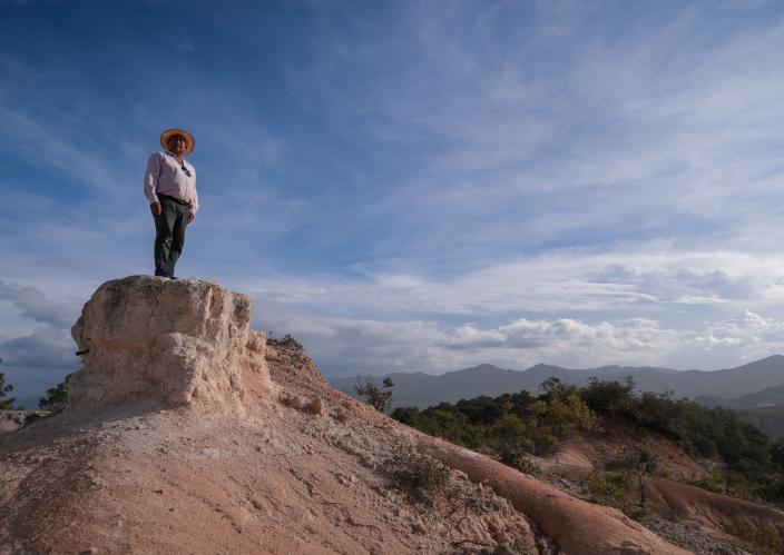 A man looking over a hill.