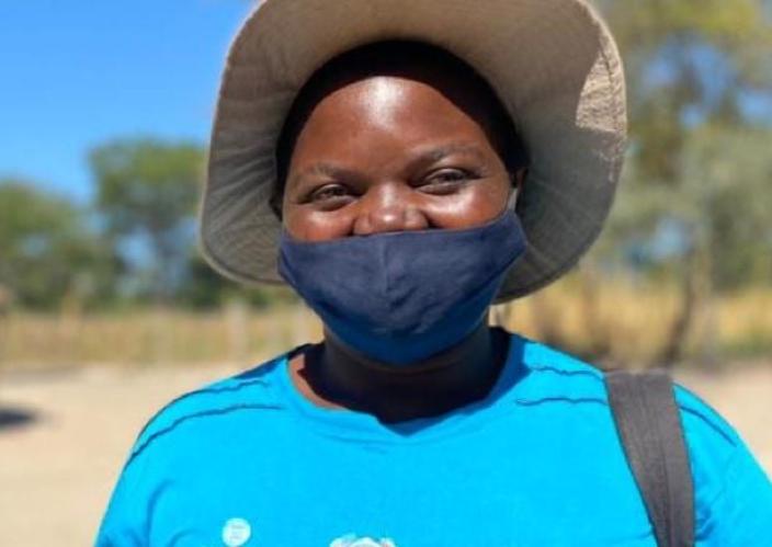 young woman with tan hat and blue mask and shirt