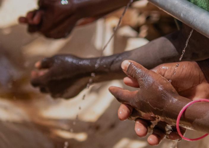 3 pairs of hands washing in clean water