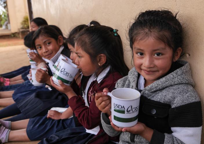 young students outside school with a snack