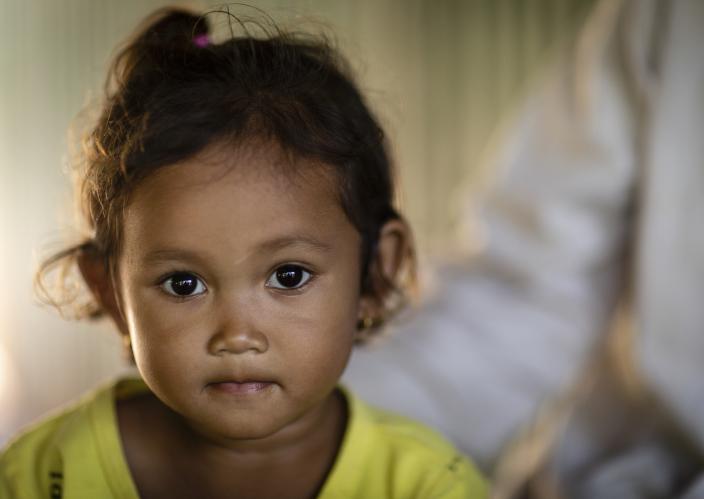 Una niña pequeña sonriendo a la cámara