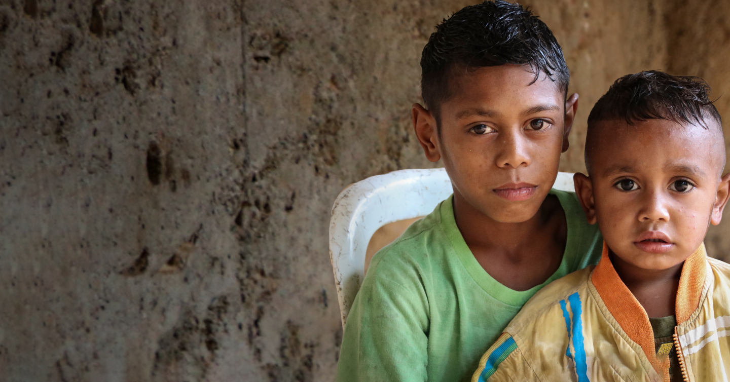 Dos niños sentados juntos con mirada desafiante.