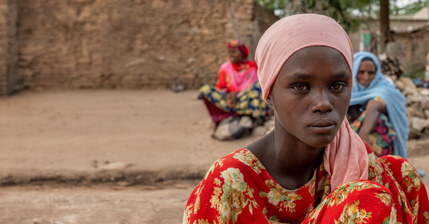 A young girl staring directly at the camera with a calm, thoughtful expression.
