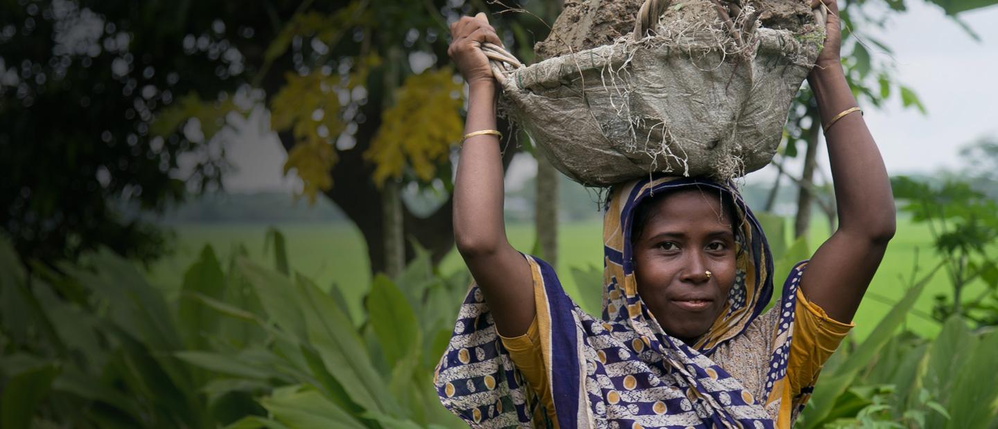 A woman carrying a basket over her head.