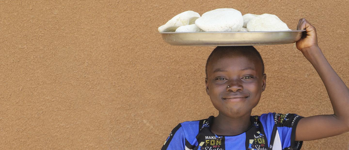 A child with a tray over her head.
