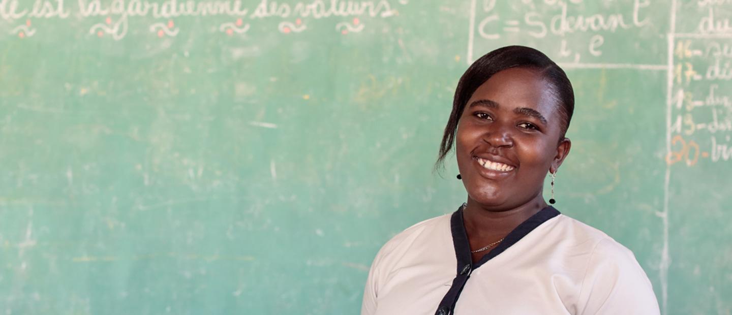 A woman in front of a classroom board.