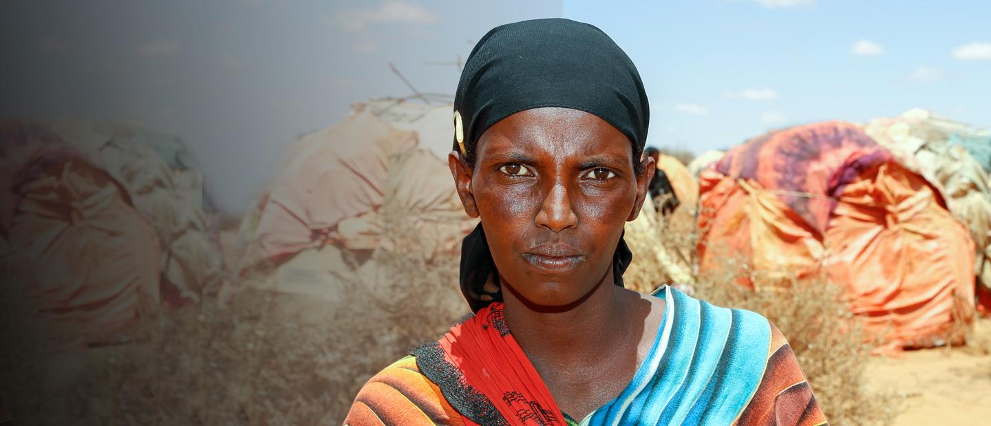 A woman in front of tents.