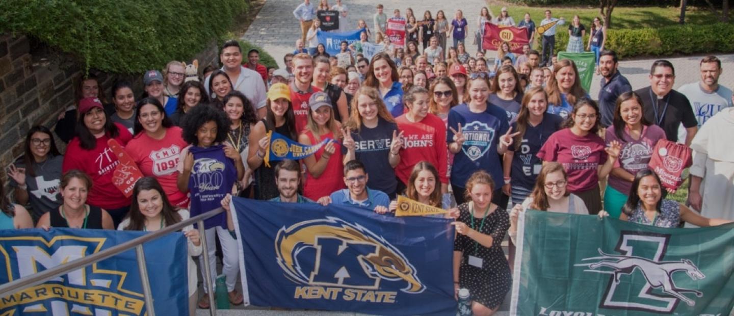 large group of college students celebrating their internships with banners