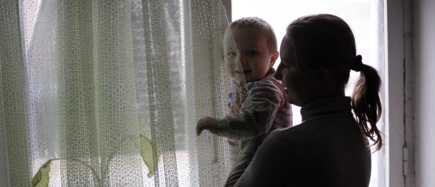 A woman and child looking out the window.
