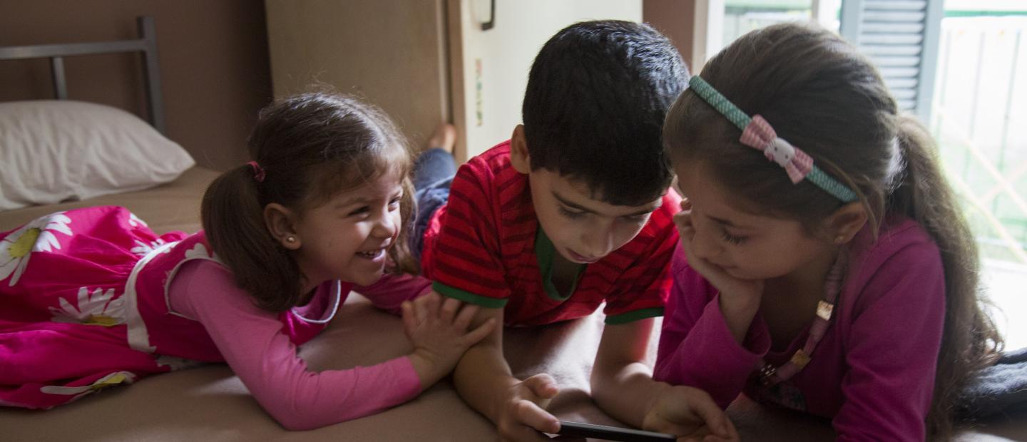 3 children playing on the floor.