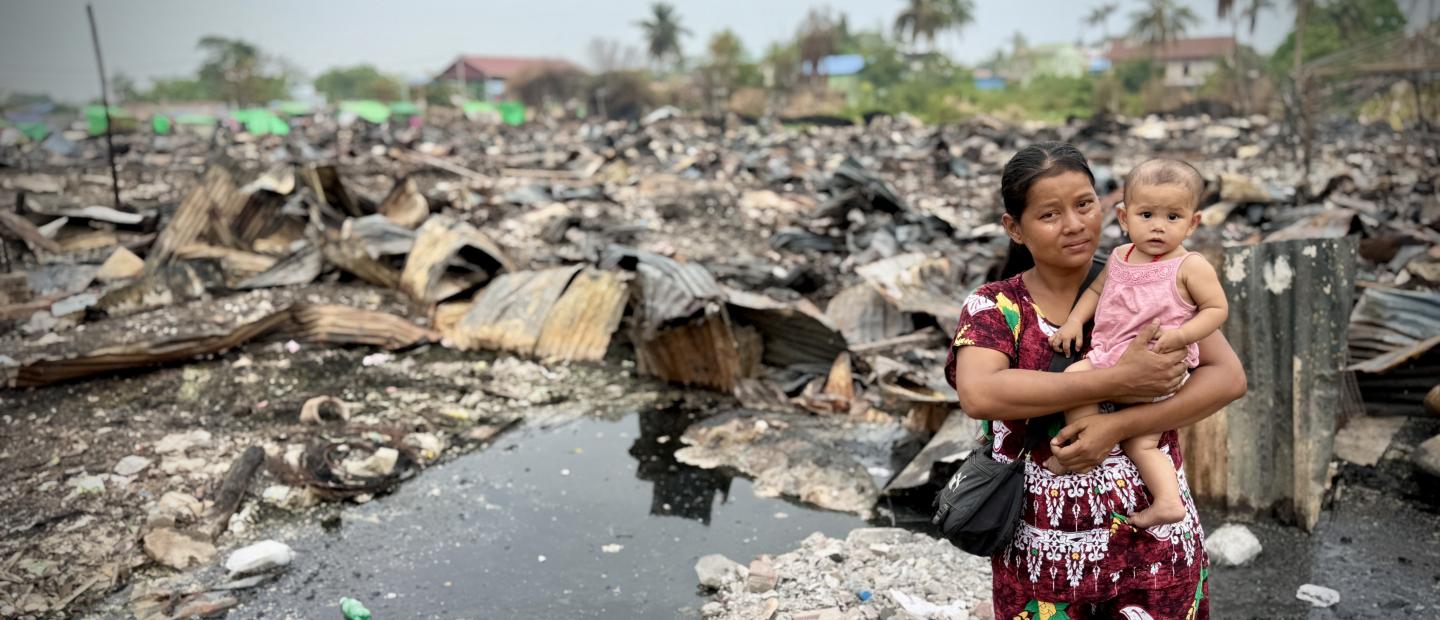 woman and baby with earthquake destruction around them