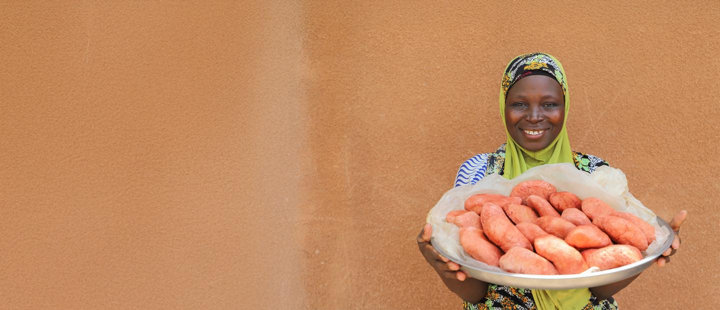 A woman holding a platter of food.