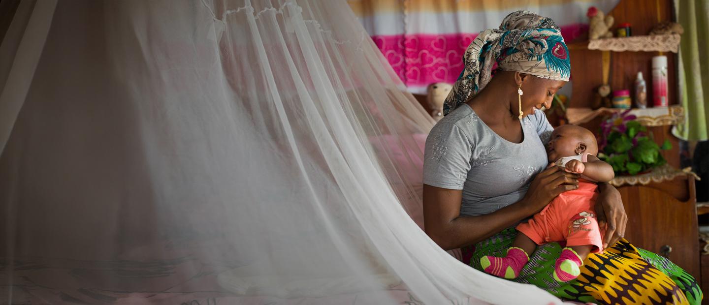 mother and baby under mosquito net