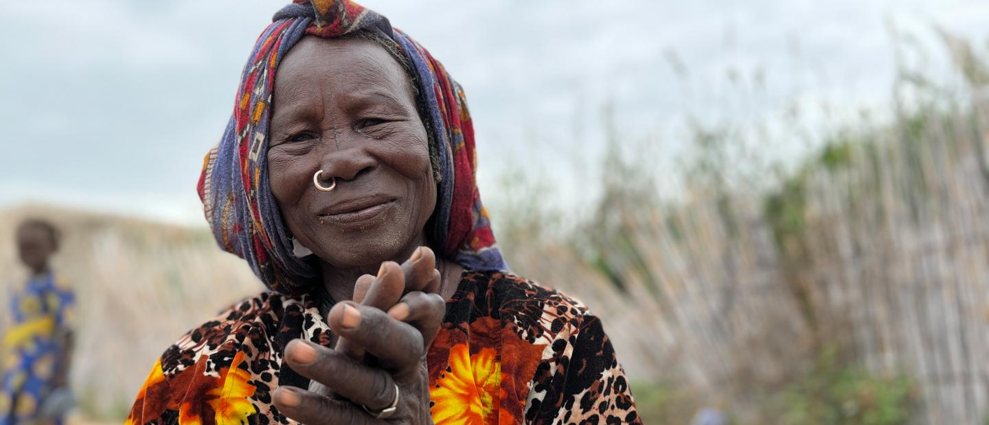 A woman with hands together in front of her.