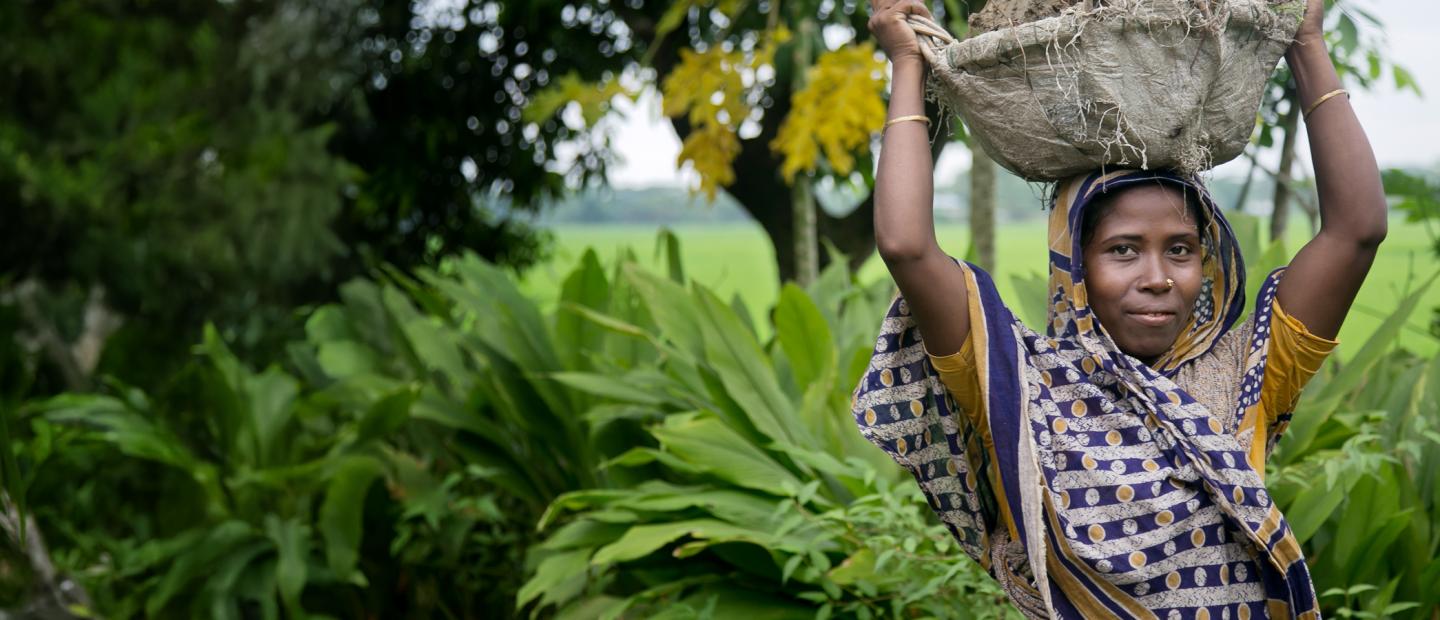 A woman holding a basket over her head.