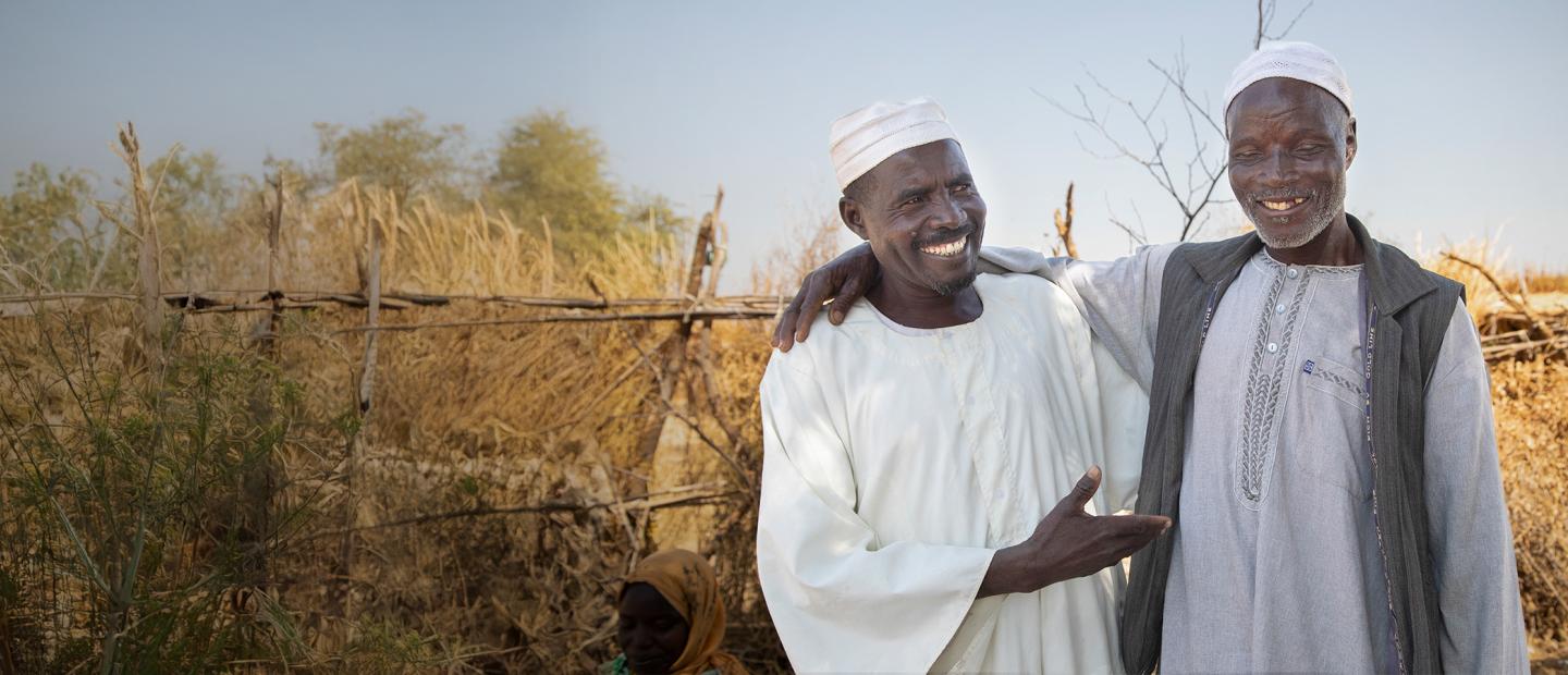 two men embracing and smiling