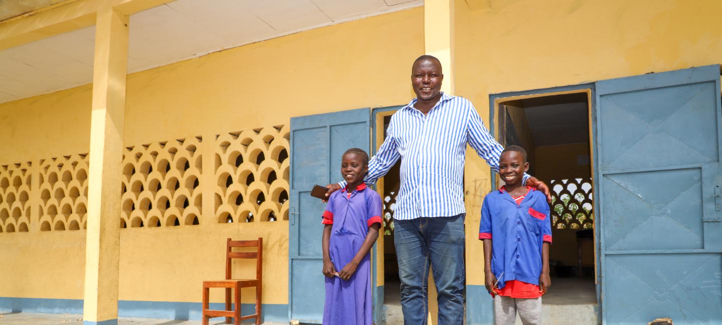 teacher stands with students at school in Cameroon