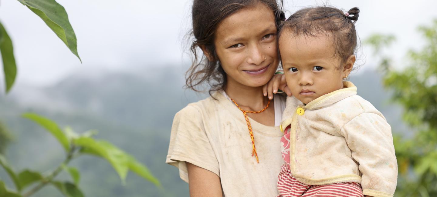 girl holding young child in Nepal