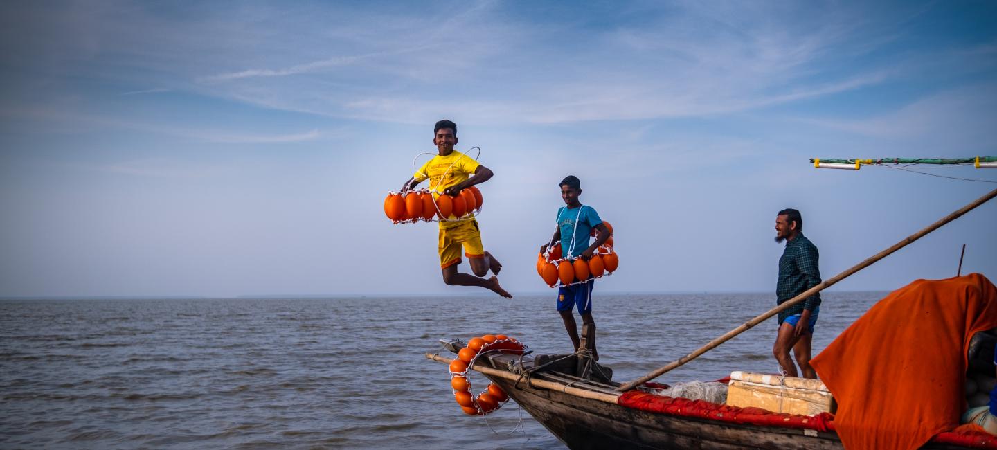 A boy jumping in the water from a boat.