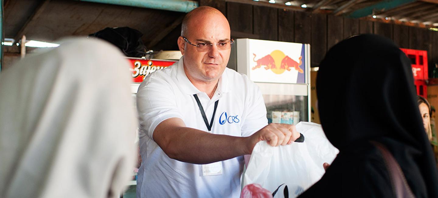 A man handing bags to people.