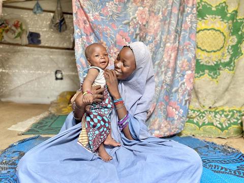mother seated with boy child on pretty fabric
