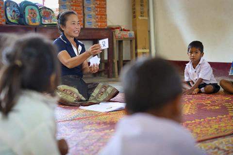 Teacher holding cards in Laos classroom