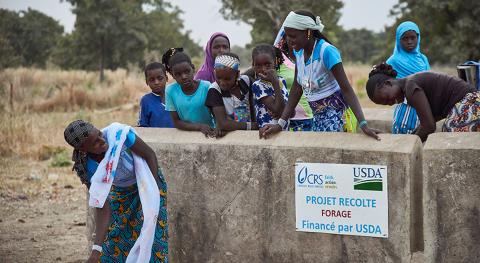people standing next to a sign that mentions CRS and USDA