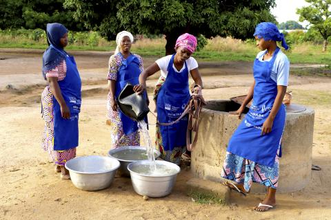Women prepare water for cooking and cleaning for school in Benin.