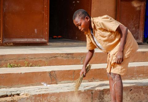 Student sweeps steps outside her school.