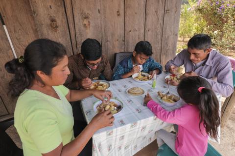 Norma, Nery and three of their children eat lunch together prepared with vegetables from their farm.
