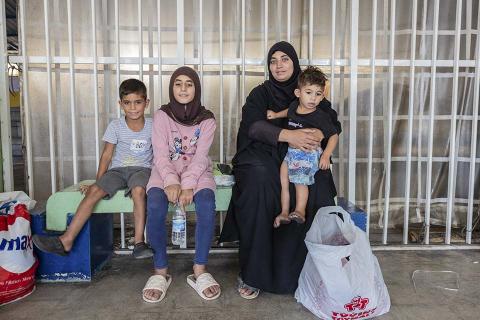 A woman with her three kids in a shelter in Lebanon