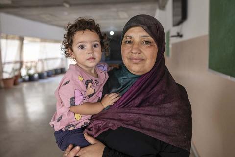 Woman holds a child in a shelter.
