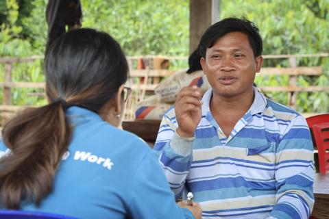 Meouy Buntear, right, shares his inspiring story with a CRS staff member.