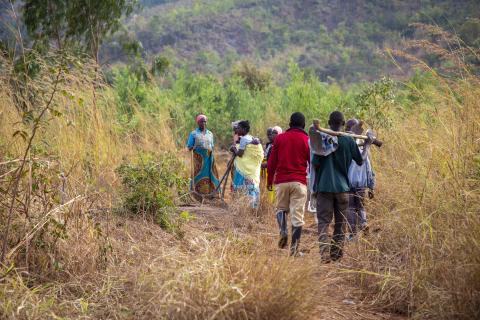 water management committee members walk along the bush path to the Lingoni river.