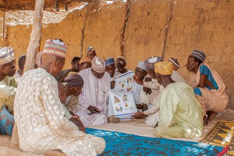 A group of men sitting on the ground.