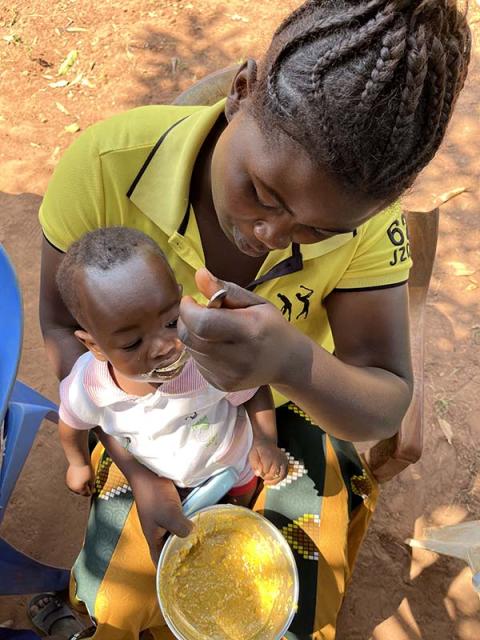 A woman feeding a child.