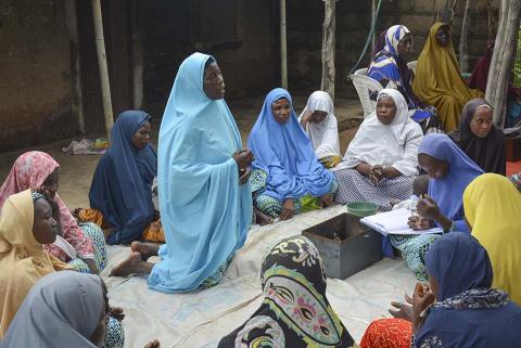 A group of woman sitting on the floor.