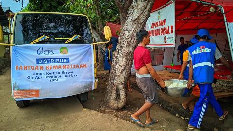 Men carrying food into a tent.