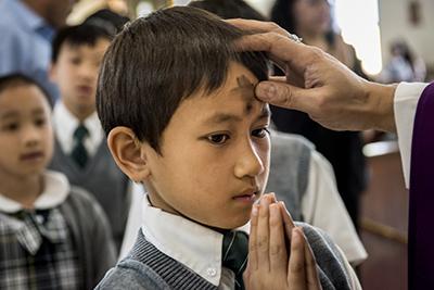 A child with ash on his forehead.
