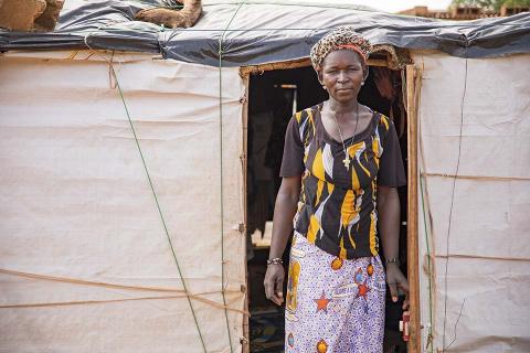 A woman standing in front of a tent.