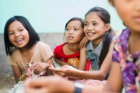 Young girls sitting next to each other.