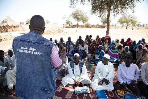 A group of men listening to CRS staff.